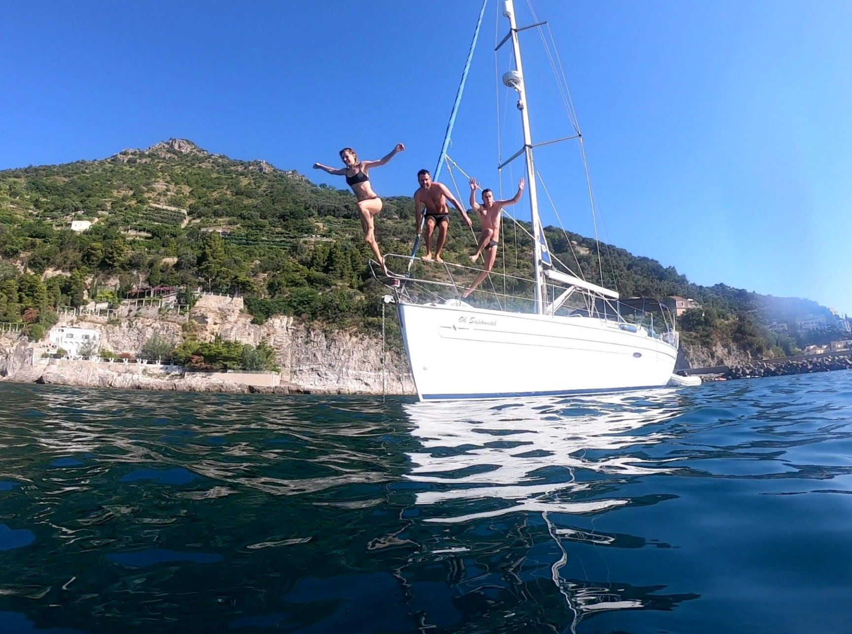 Guests jumping off the deck into the crystal-clear waters of the Amalfi Coast